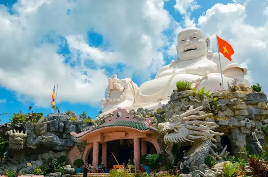 Tượng Phật Di Lặc uy nghi giữa vườn xanh, biểu tượng của sự thịnh vượng và hạnh phúc.